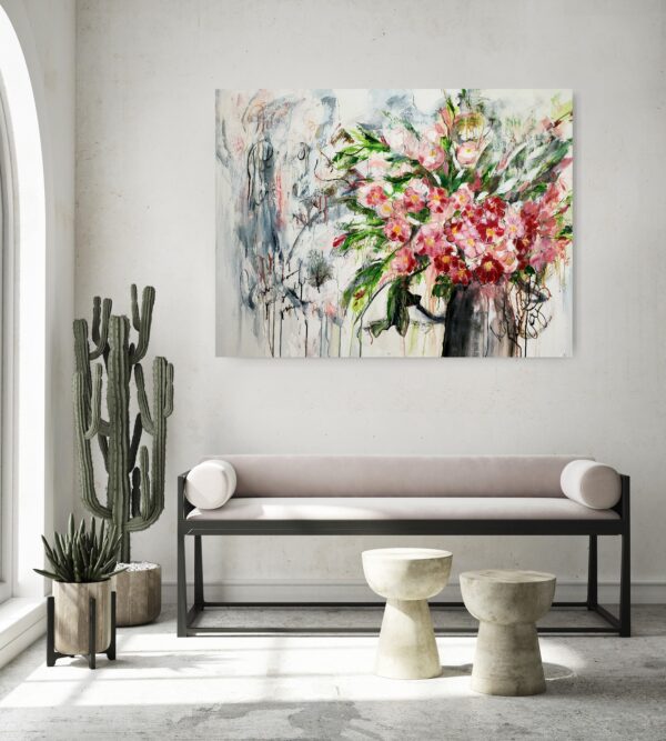 Spring's Grace - This abstracted mixed media artwork portrays a vase of red and pink luscious flowers sitting amidst luscious green foliage. The abstract background adds interest to the overall composition of the painting. This painting is hanging on a pale wall behind a sofa, coffee tables and pot plants to the left.