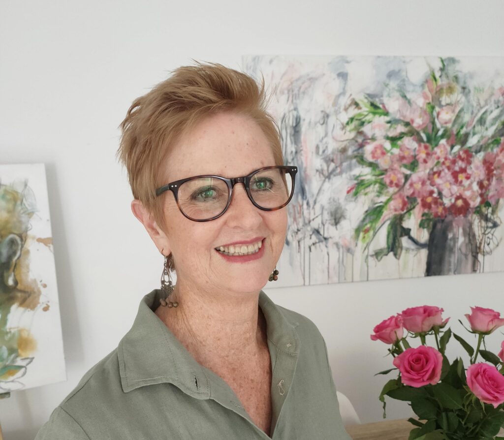 This shows Maia Martin photographed amongst some of her artwork and flowers.