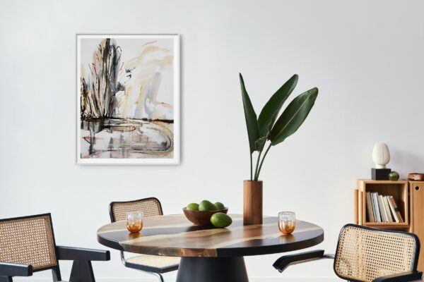 Mist on the Lake - This abstract mixed media artwork portrays an estuary or lake with reflection of ochre, rich copper and black trees amidst a cloudy sky. The painting is hanging on a white wall in front of tables and chairs with decorating items. The painting is hanging on a pale wall behind a dining table, chairs and decorating items.