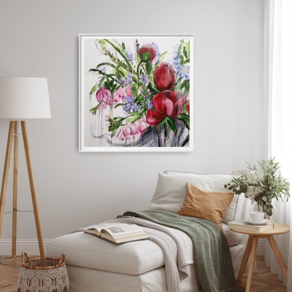 Opulence - This abstract mixed media artwork represents the beauty of nature with a vase of opulent red, pink and purple flowers amongst luscious green foliage. It is hanging on a white wall with a chaise lounge. There is a small table with a book, teacup, and vase of flowers beside. Also there is a standing lamp and small basket as decorating items.