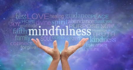 mindfulness meditation - female hands reaching up towards the word 'mindfulness' floating above surrounded by a relevant word cloud on an ethereal blue night sky background