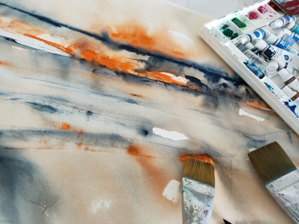 Watercolour painting in progress with tray of paints and brushes to one side