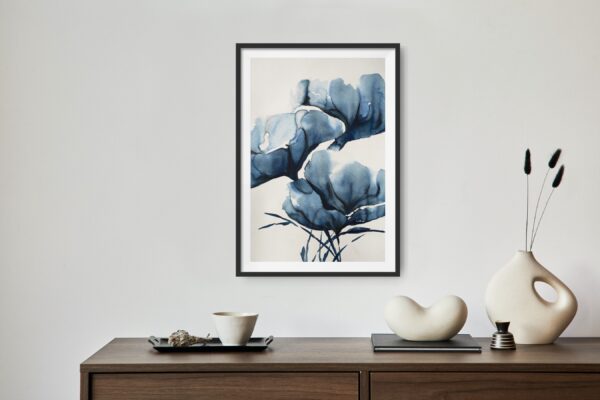 Abstract artwork of blue magnolias in an Asian inspired painting hanging over a desk with decorating items.