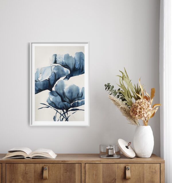 Abstract artwork of blue magnolias in an Asian inspired painting hanging over a cabinet with decorating items.